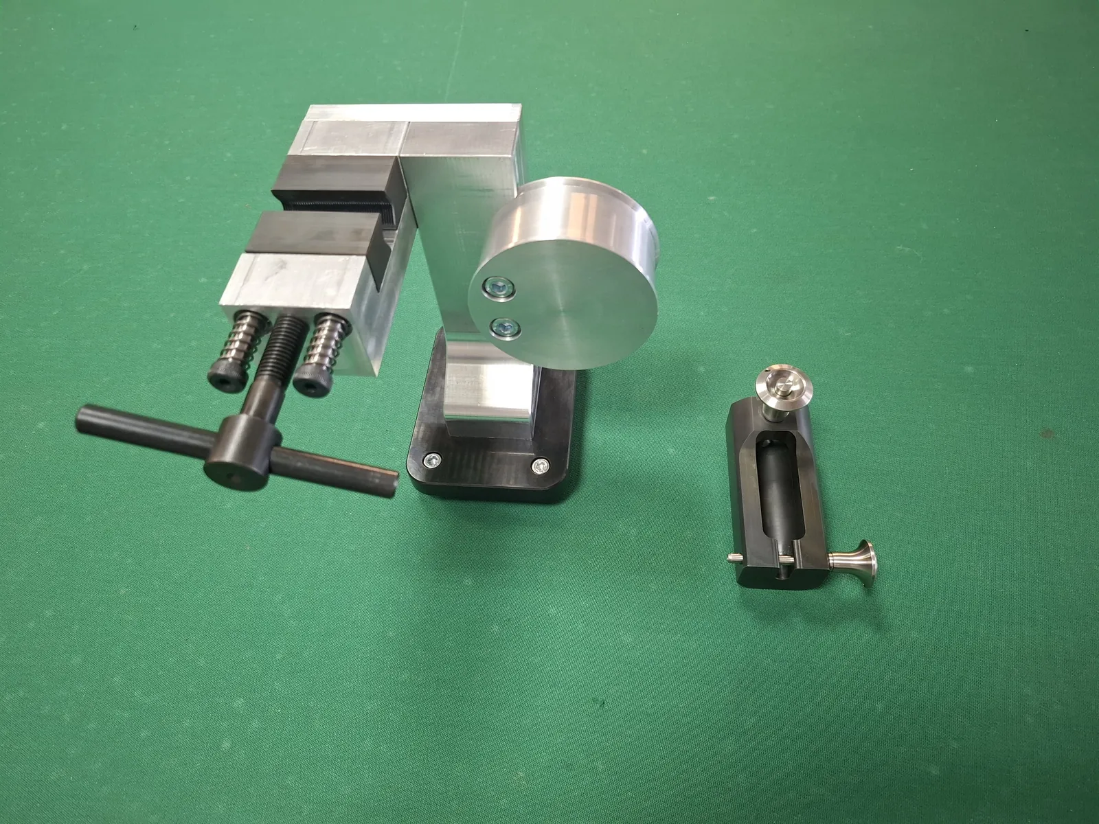 Aluminium and steel parts: a small vice with a handle, a disc and a small clamp