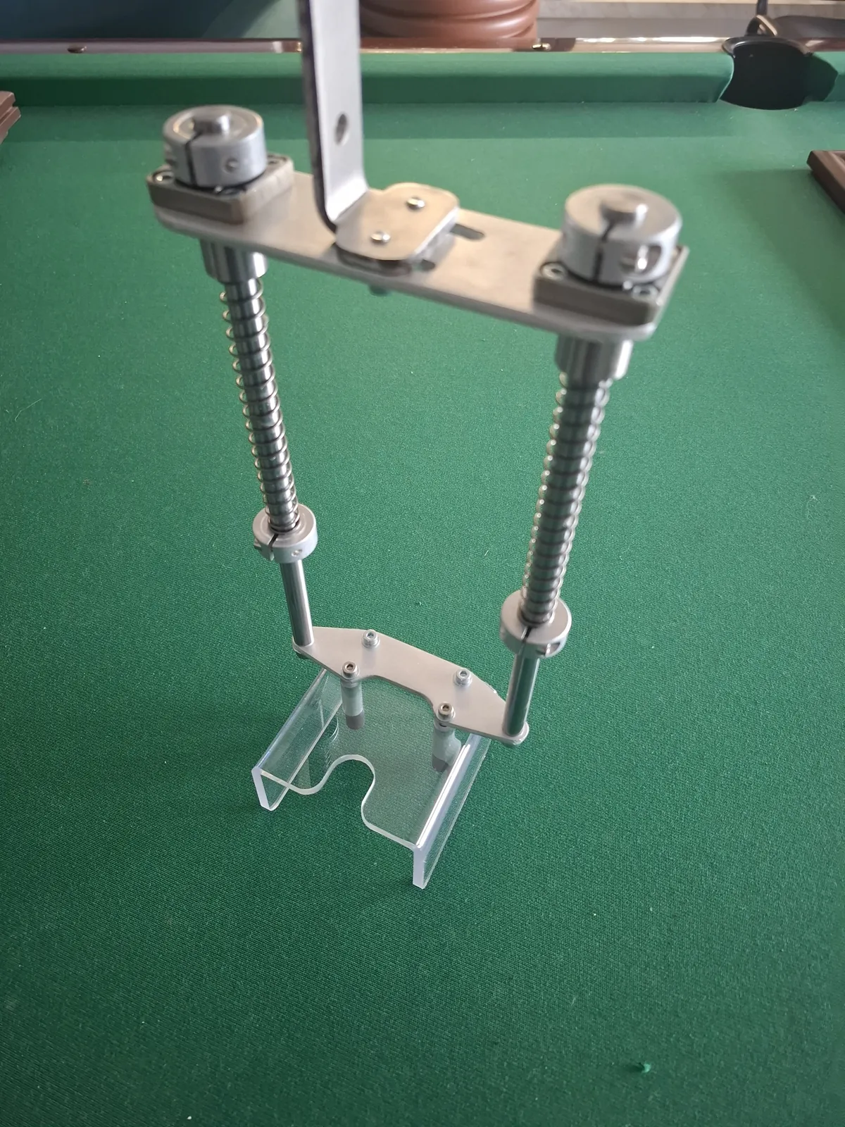 Mechanism with two screws with nuts and a transparent part at the bottom