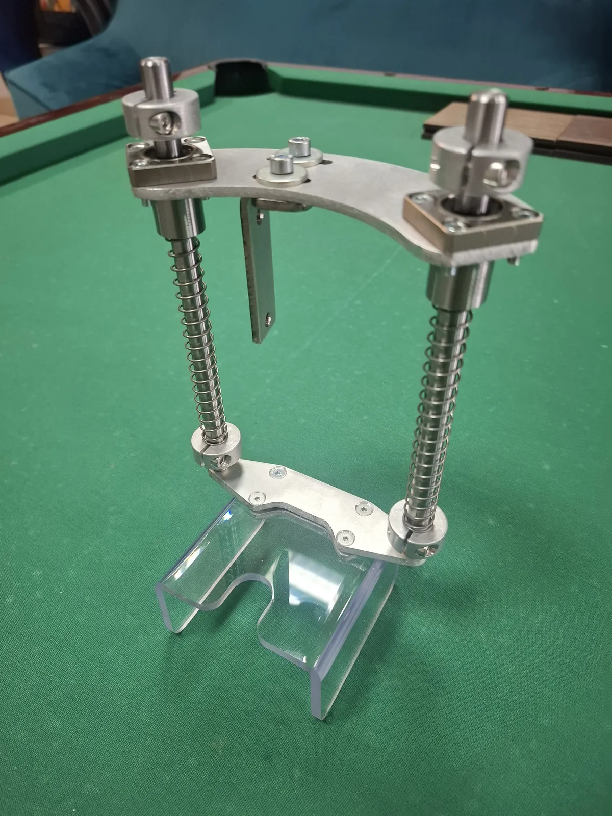 Mechanism with two screws with nuts and a transparent part at the bottom, another view