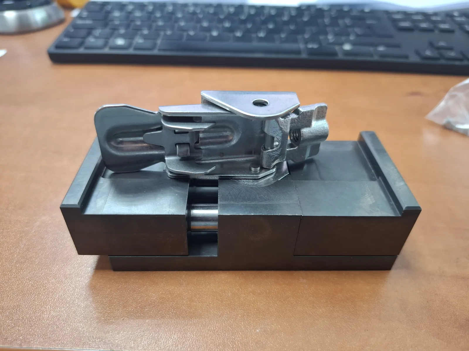 Metal clamping part on a black base with a guide