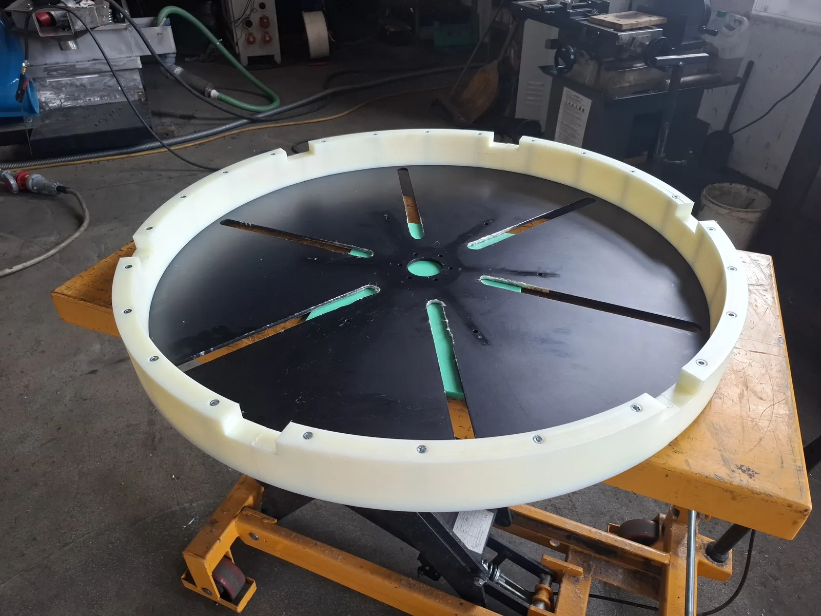 Round disc with a light rim and a black plate on a scissor lift